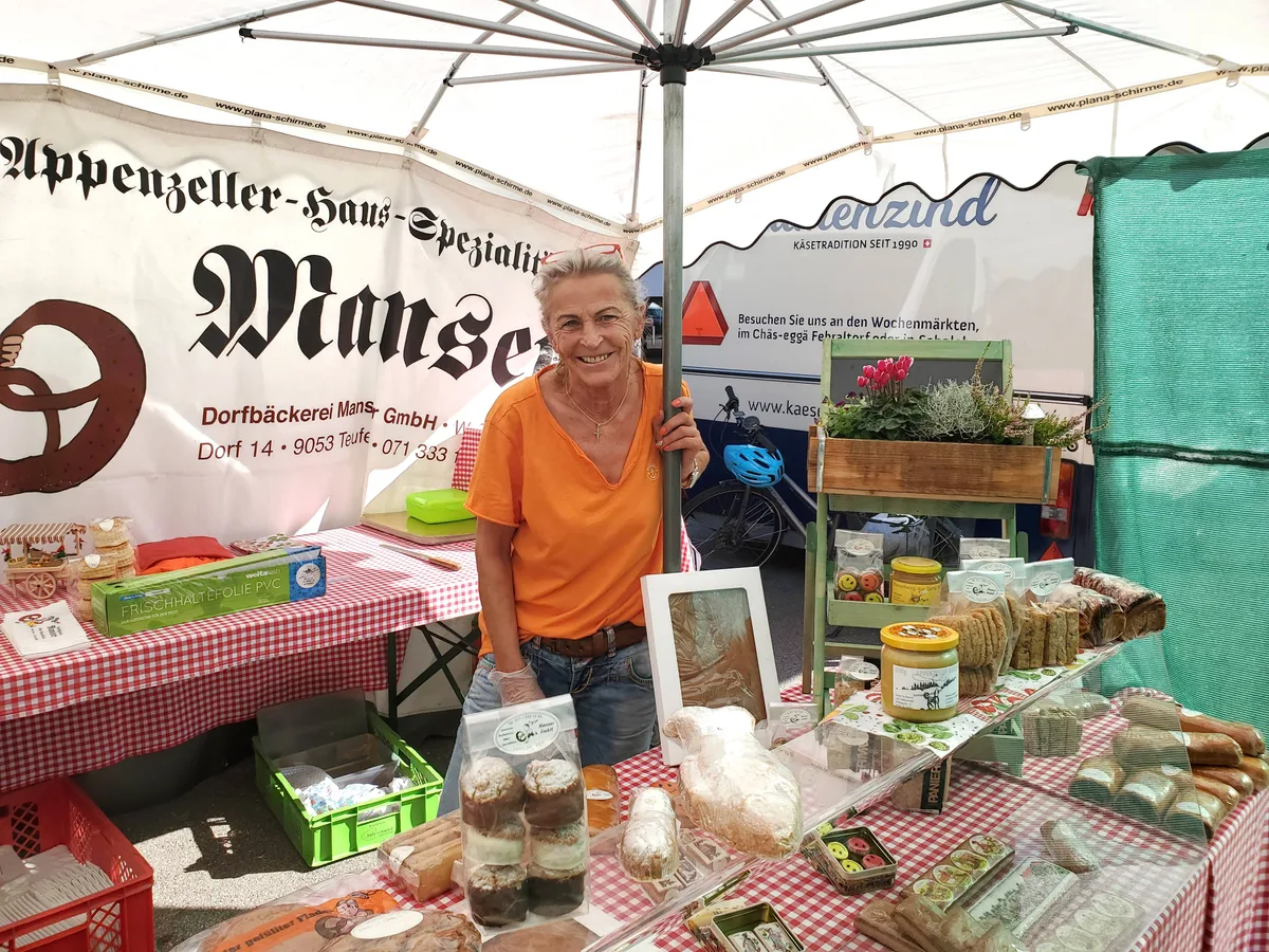 Eine Frau an einem Gebäckstand.